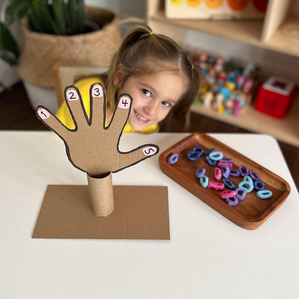 Unlock the fun of Counting to 5 with our engaging number recognition activity! Explore numbers 1 through 5 as little ones match hairbands to each finger of a playful cardboard hand, making learning a hands-on adventure.