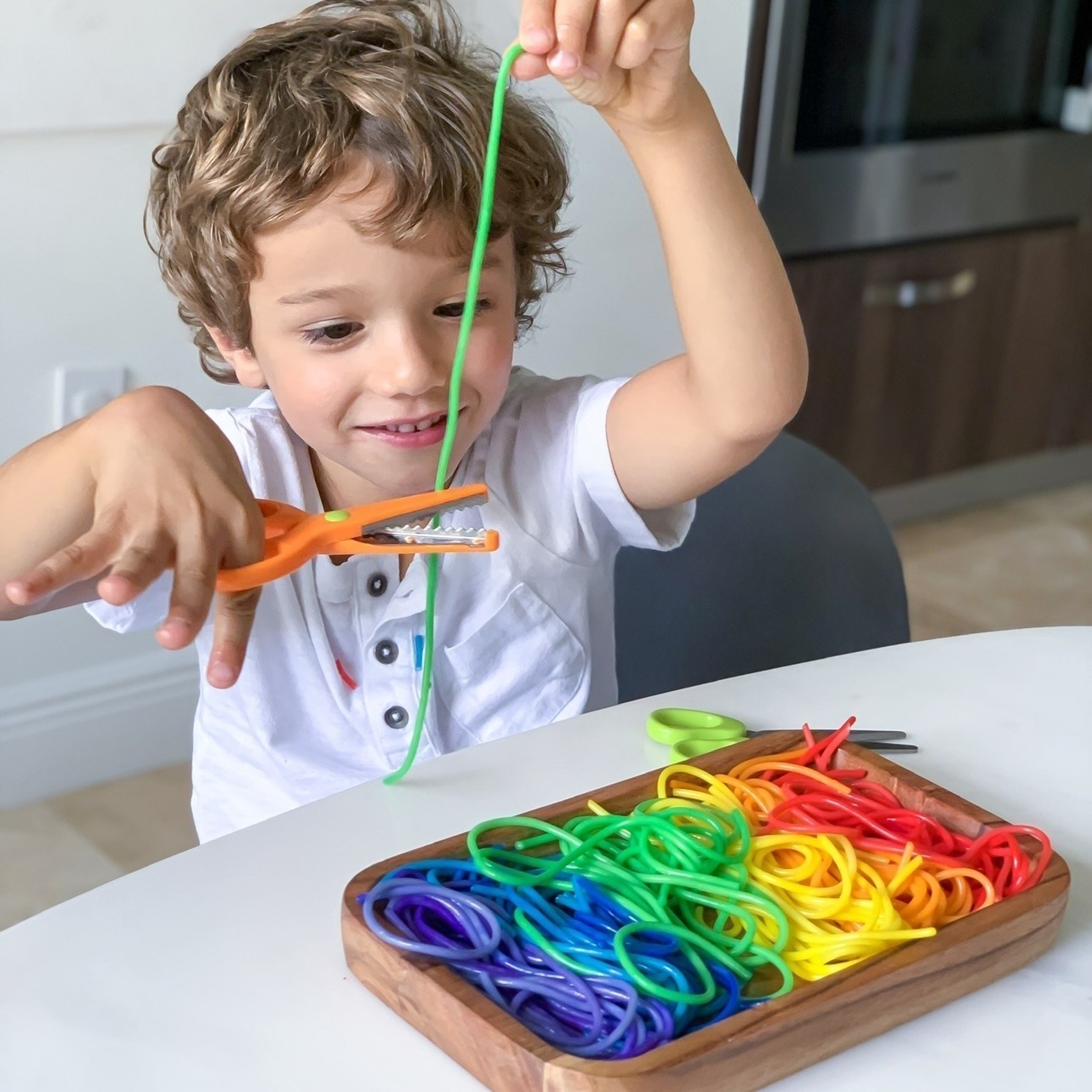 Cut the pasta snacktivity for kids using rainbow colored pasta