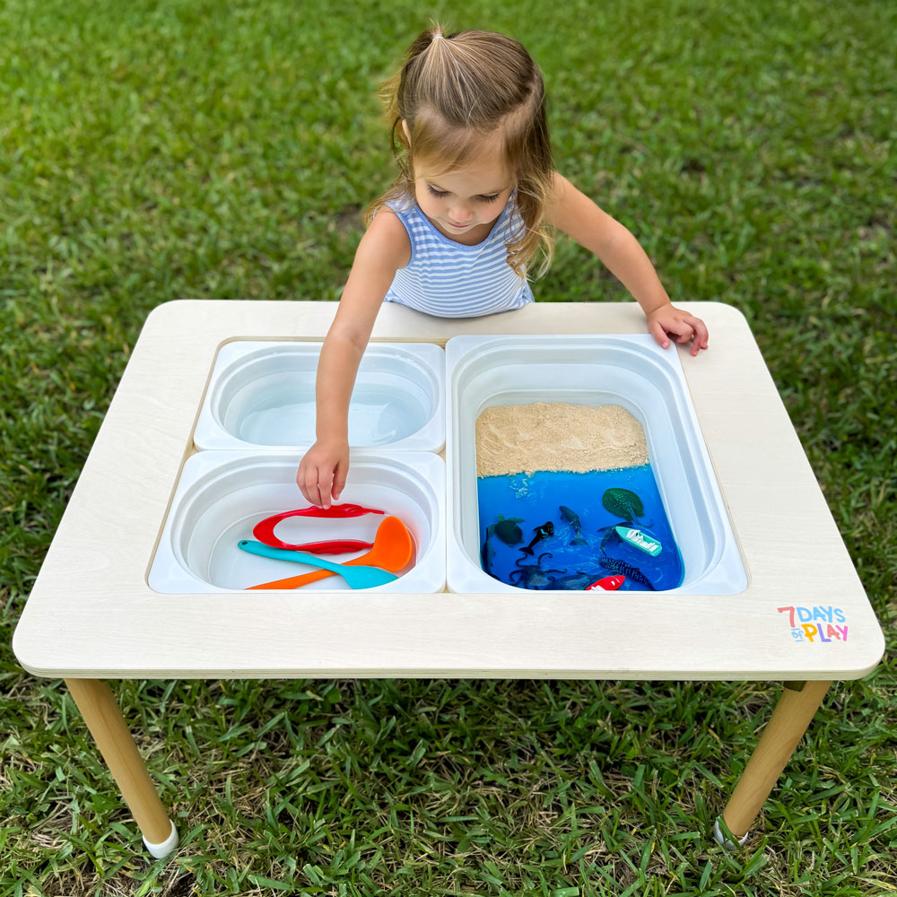 ocean sensory bin on activity table by 7 days of play. Child playing with marine creatures animals and taste safe jello for the ocean and cherros for the sand. great activity for toddlers
